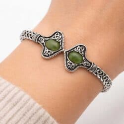 Silver tone Connemara Marble torc-style cuff bracelet with Celtic knot detailing. Unisex Irish design with hinged fit, timeless and meaningful.