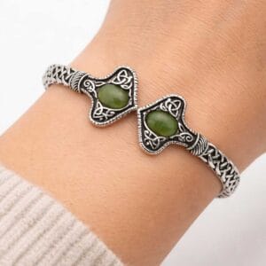 Silver tone Connemara Marble torc-style cuff bracelet with Celtic knot detailing. Unisex Irish design with hinged fit, timeless and meaningful.